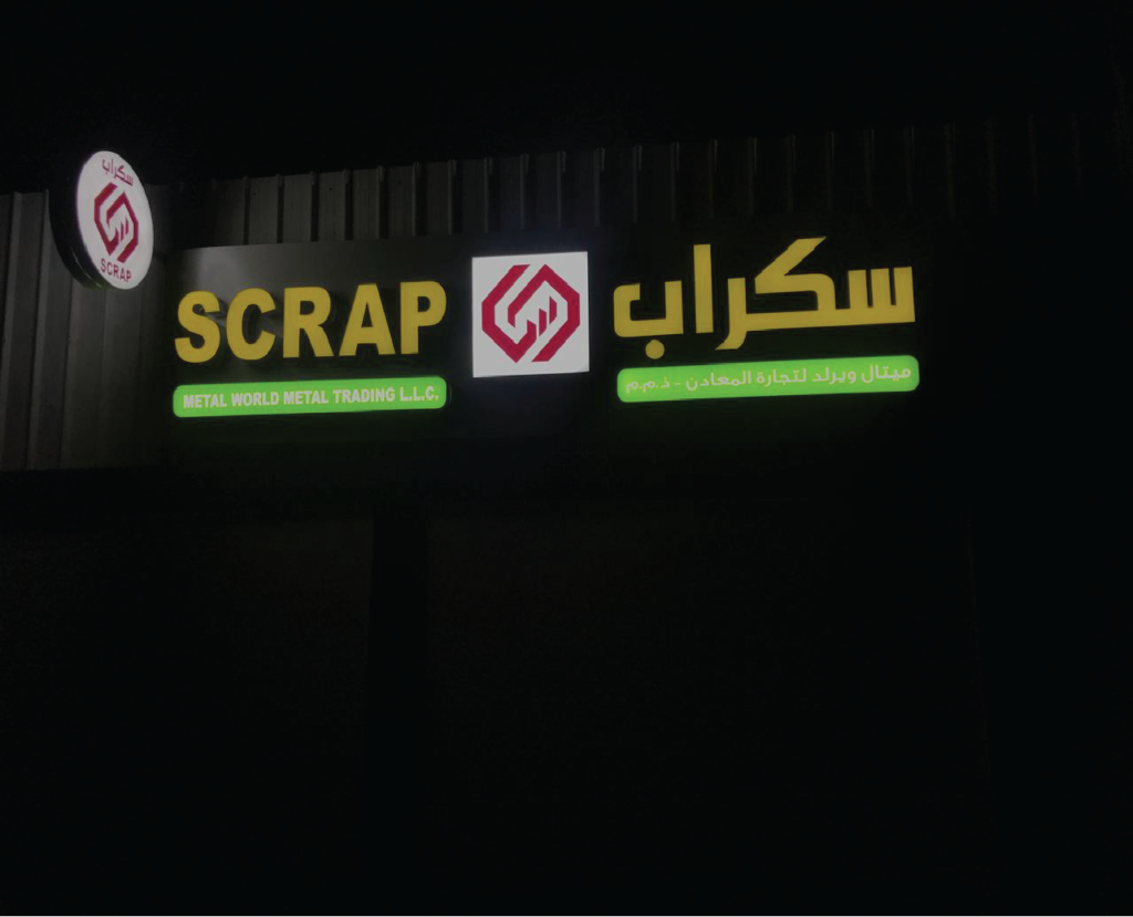 Outdoor signage for a scrap metal shop in Abu Dhabi, featuring bold lettering and images of metal scraps. The signage is strategically placed to attract customers and inform them about the shop's services.